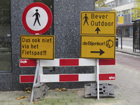 908112 Afbeelding van enkele verwarrende richtingborden op een afsluitingshek bij de St. Jacobsstraat te Utrecht.